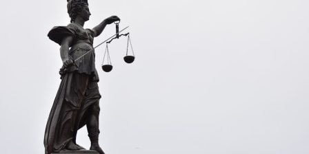 A statue of lady justice holding a scale of justice