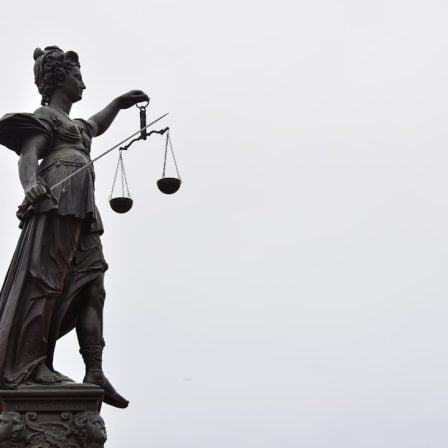 A statue of lady justice holding a scale of justice